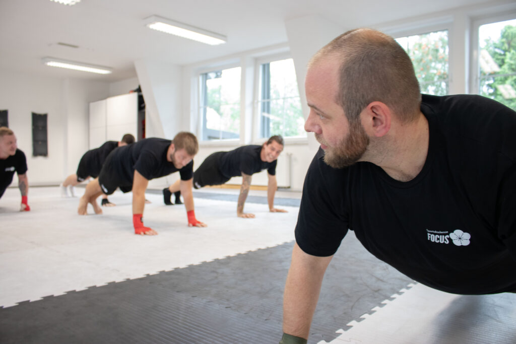 Die Schüler der Kampfsportschule machen Liegestützen.