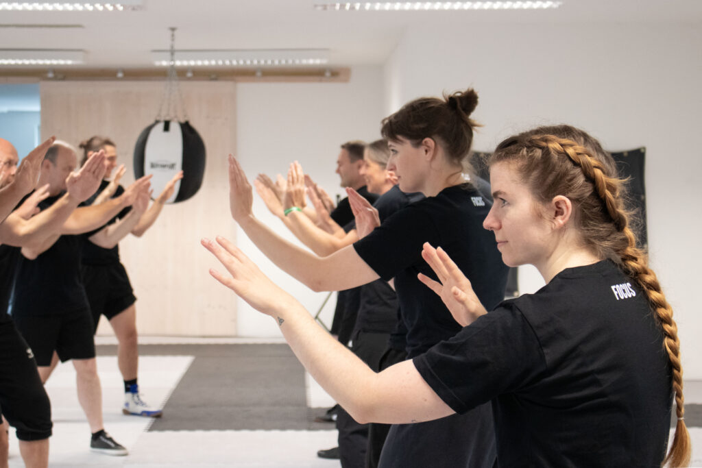 Die Schüler stehen sich in zwei Reihen gegenüber und führen ihre erlernten Wing Chun Techniken aus.
