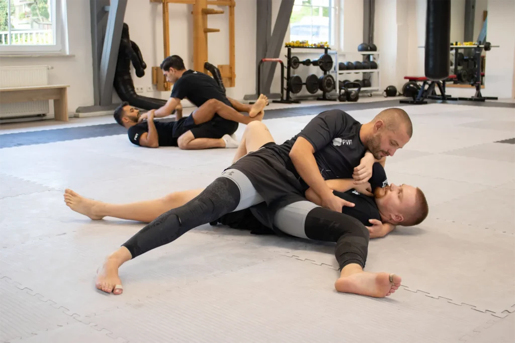 Vier Männer im Grappling-Training, liegen am Boden und trainieren.