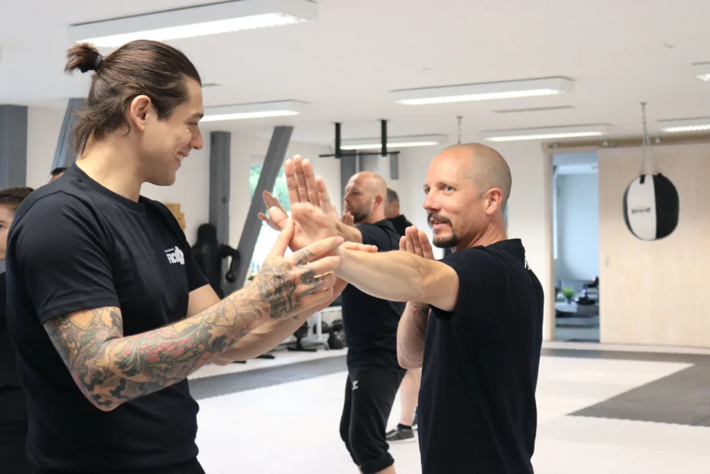 Der Kampfsport-Trainer zeigt dem Schüler eine Technik aus dem Wing Chun.